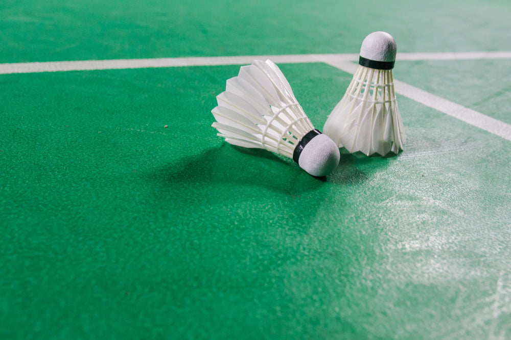 Two badminton shuttles on a badminton court