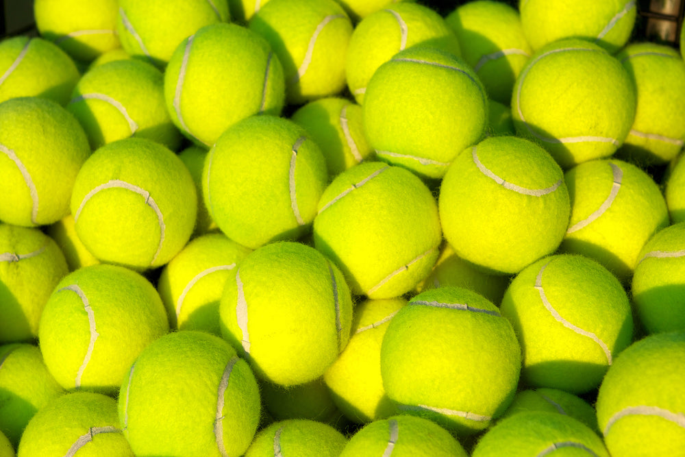 Lots of tennis balls in a pile